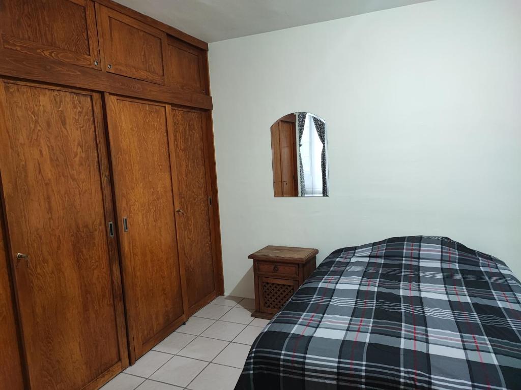 een slaapkamer met een bed en houten kasten bij Departamento independiente en Durango México 