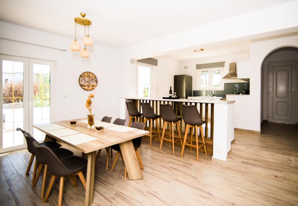 een keuken en eetkamer met een houten tafel en stoelen bij Villa Zou in Ambelas