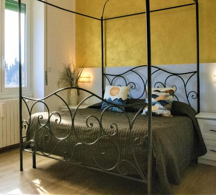 een slaapkamer met een metalen bed met 2 kussens bij Dea Tiburtina in Rome