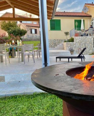 a fire pit in a yard with a table and chairs at Villa Yucca Istra in Labin