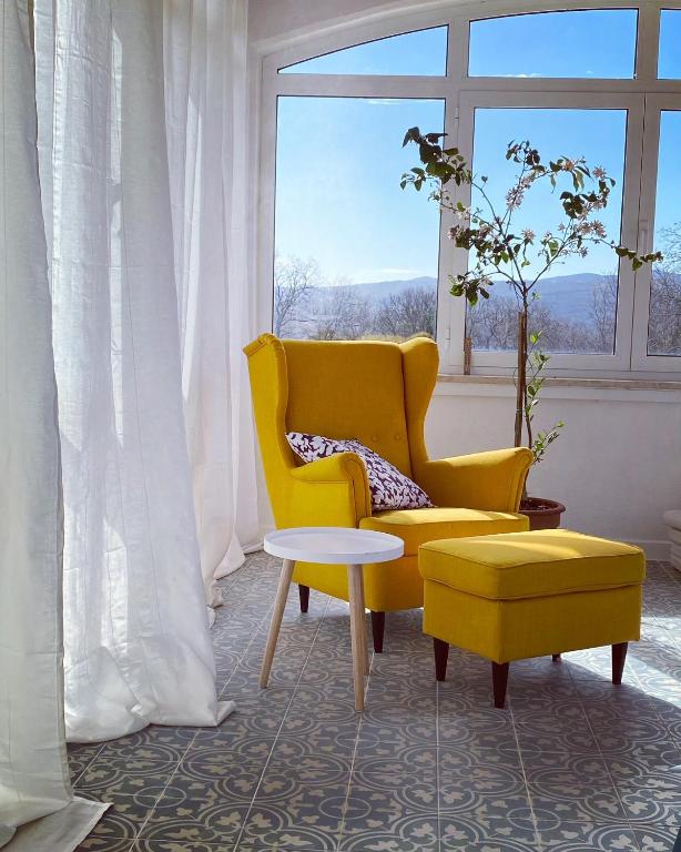 a yellow chair and a table in a room with a window at Villa Yucca Istra in Labin