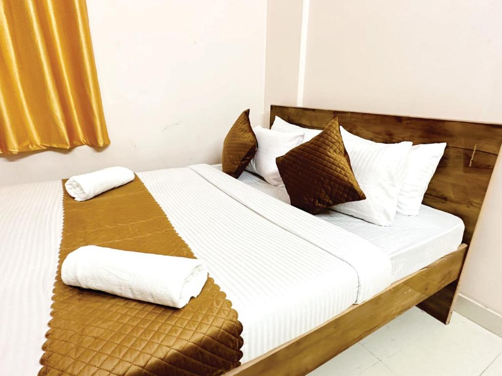 sypialnia z łóżkiem z białą pościelą i poduszkami w obiekcie VHB Inn w mieście Jigani