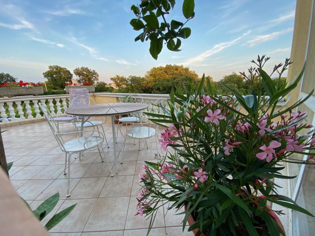 a patio with a table and chairs and flowers at Villa Yucca Istra in Labin