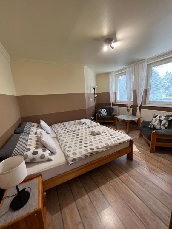 a bedroom with a large bed and a living room at Holler Vendégház II. in Bük