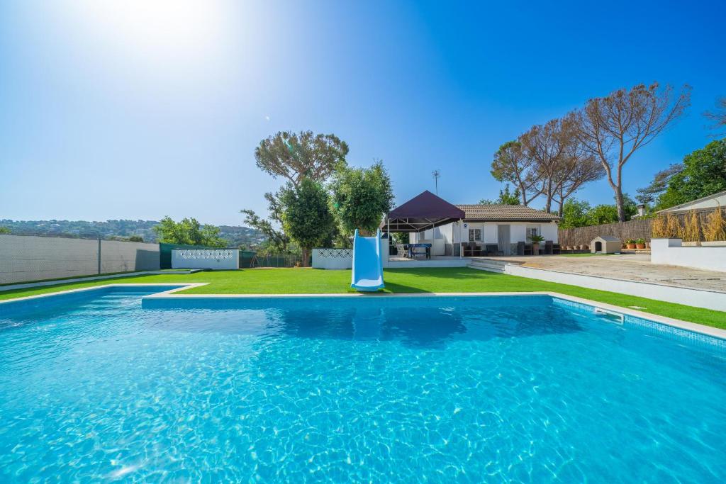 a swimming pool in a yard with a house at HomeHolidaysRentals Adaggio - Costa Barcelona in Fogás de Tordera
