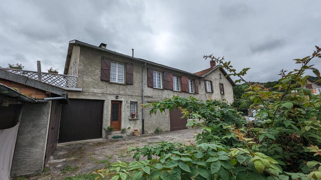 an old house with a garage in a yard at La maison du sabotier in Audressein