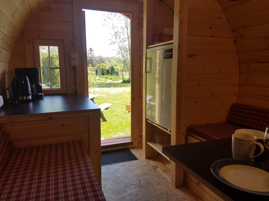 una cocina en una cabaña de madera con fregadero y ventana en Barrel in Oostvoorne, en Oostvoorne