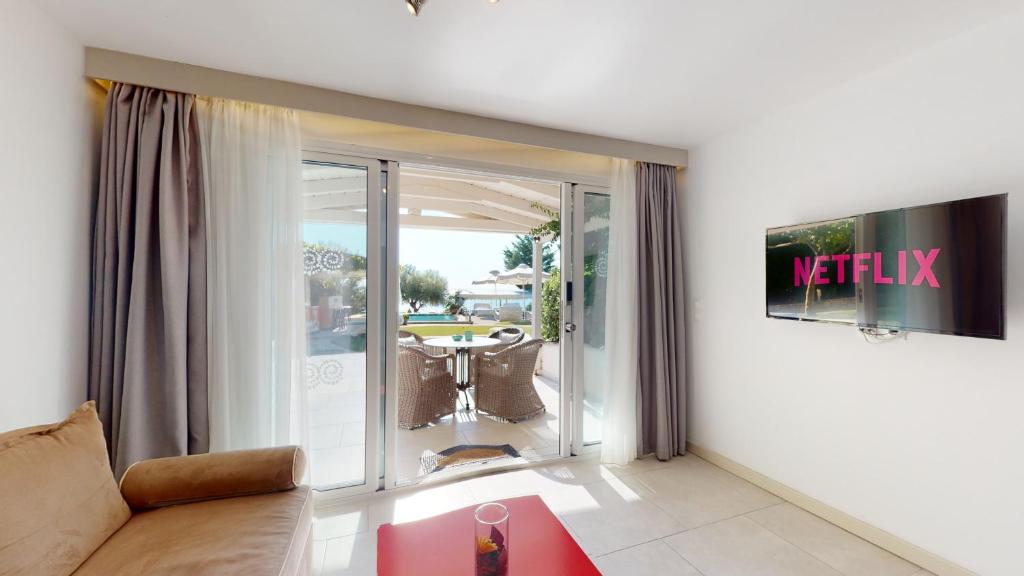 a living room with a couch and a view of a table at Acrotel Athena Villa in Elia