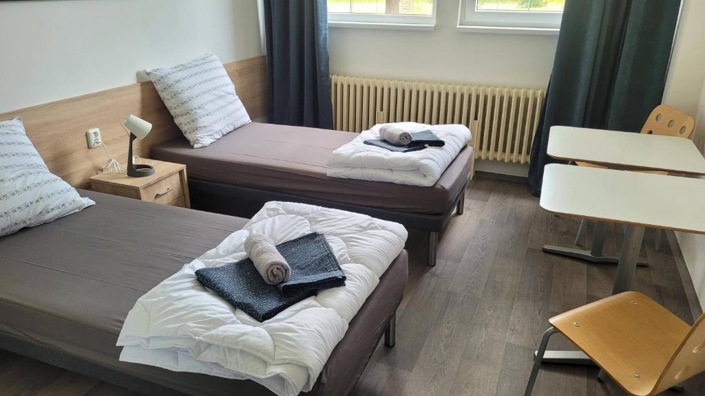 um quarto com duas camas com toalhas em ABO Penzion Chomutov em Chomutov