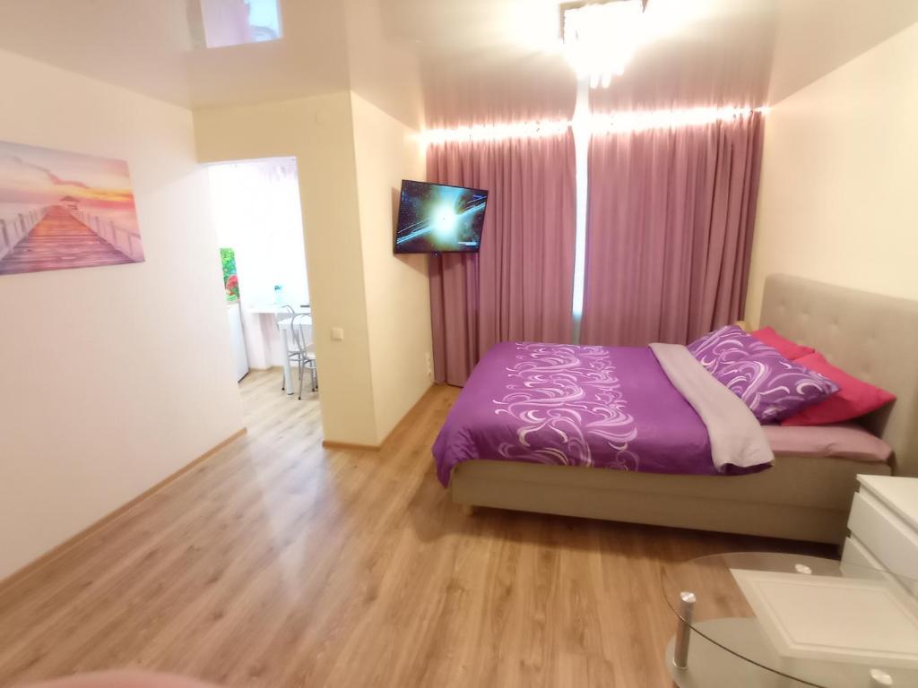 a bedroom with a purple bed and a window at Perfect Studio in Narva center in Narva