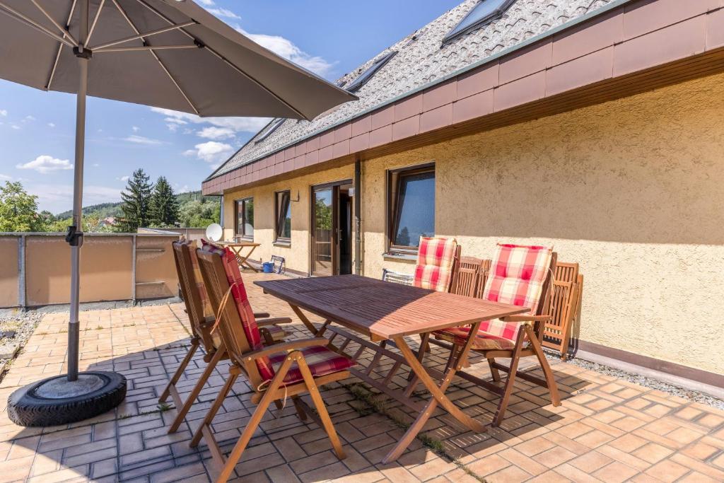 a wooden table and chairs with an umbrella on a patio at B463 Penthouse in Albstadt