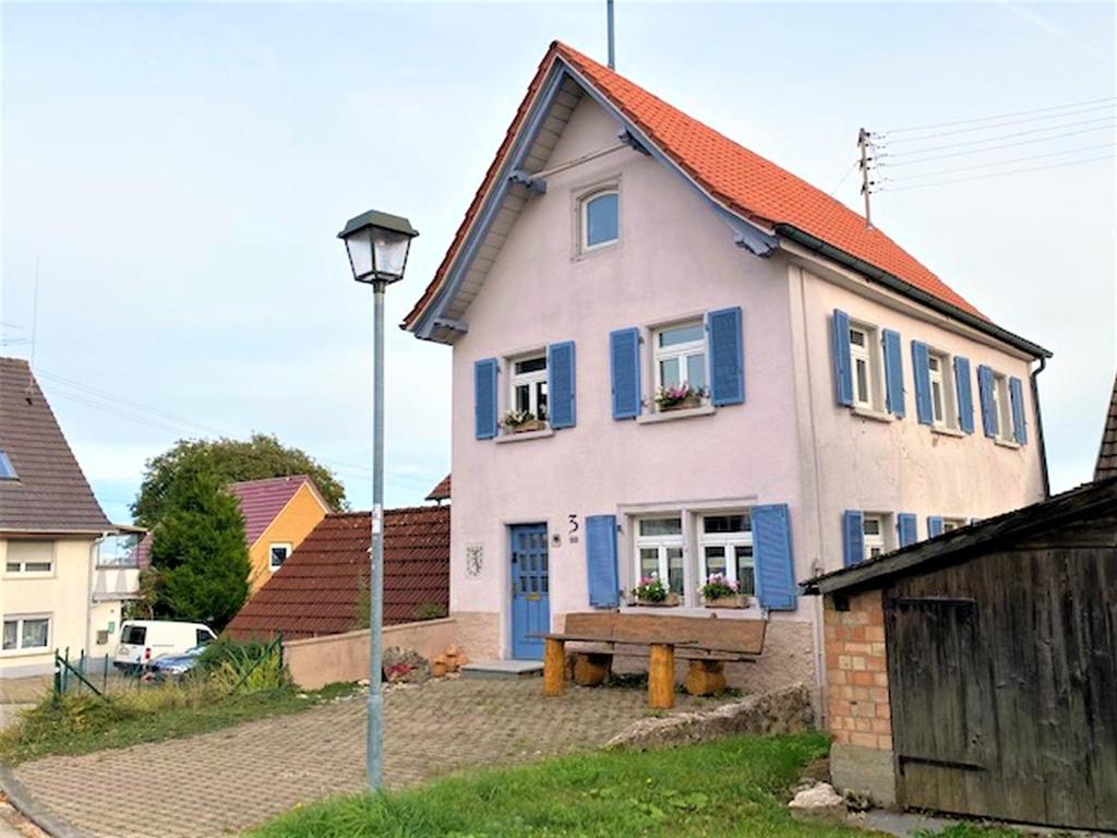 a white and blue house with blue shutters at Altes Rathaus in Leibertingen