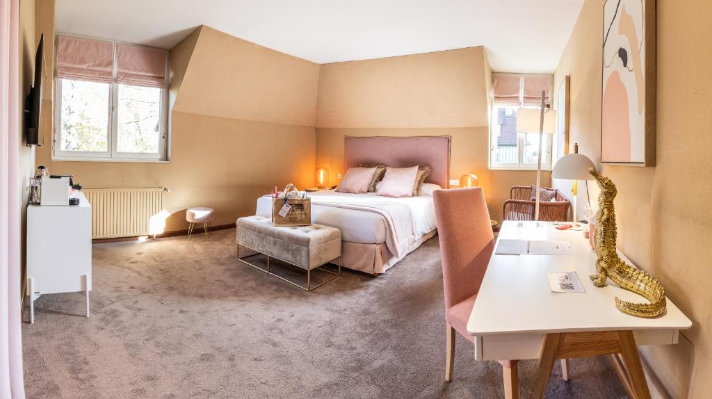a hotel room with a bed and a table at Le Manoir De La Poterie & Spa in Cricquebœuf