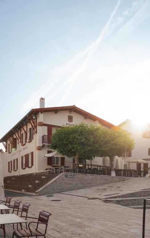 een gebouw met tafels en stoelen ervoor bij Auberge Koskenia in Bidart