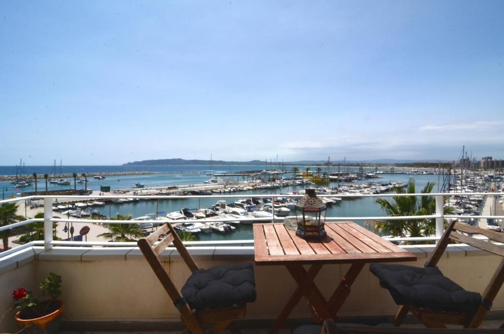een tafel en stoelen op een balkon met een jachthaven bij Escorpora in L'Estartit