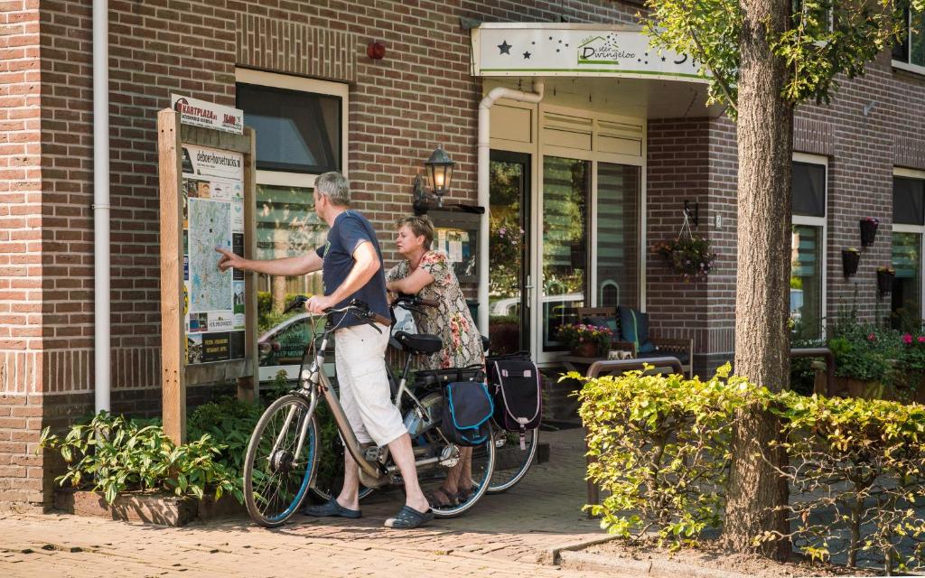 a man and a woman standing next to a bike at B&B de Ster van Dwingeloo in Dwingeloo