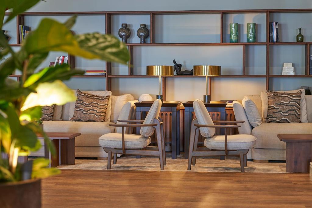 a room with couches and a table and chairs at The Cliff Bay - PortoBay in Funchal