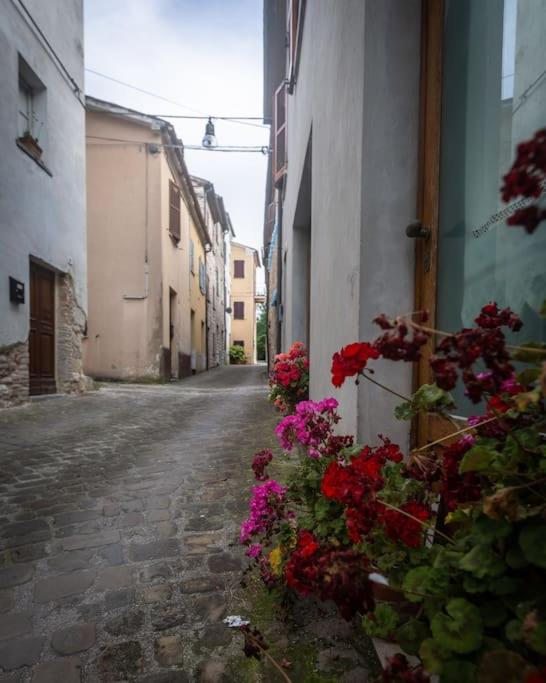 un callejón con flores al lado de un edificio en Nel tranquillo centro d'Isola en Isola di Fano