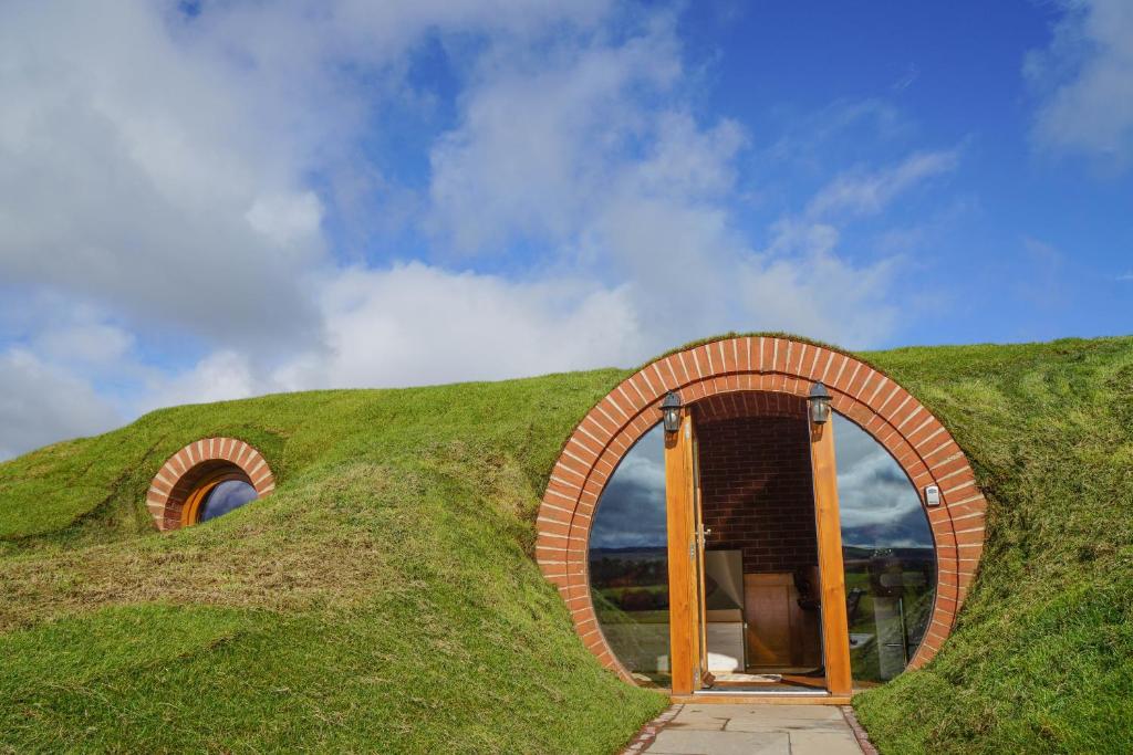 a house built on top of a grassy hill at Hares View in Rhayader
