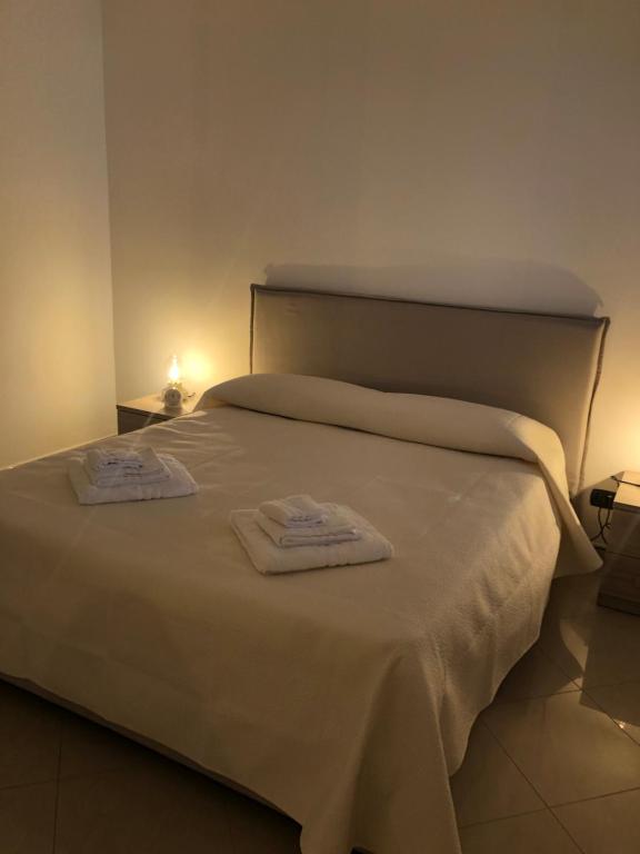 un letto bianco con due asciugamani sopra di Rosabella Casa Vacanze a Bari
