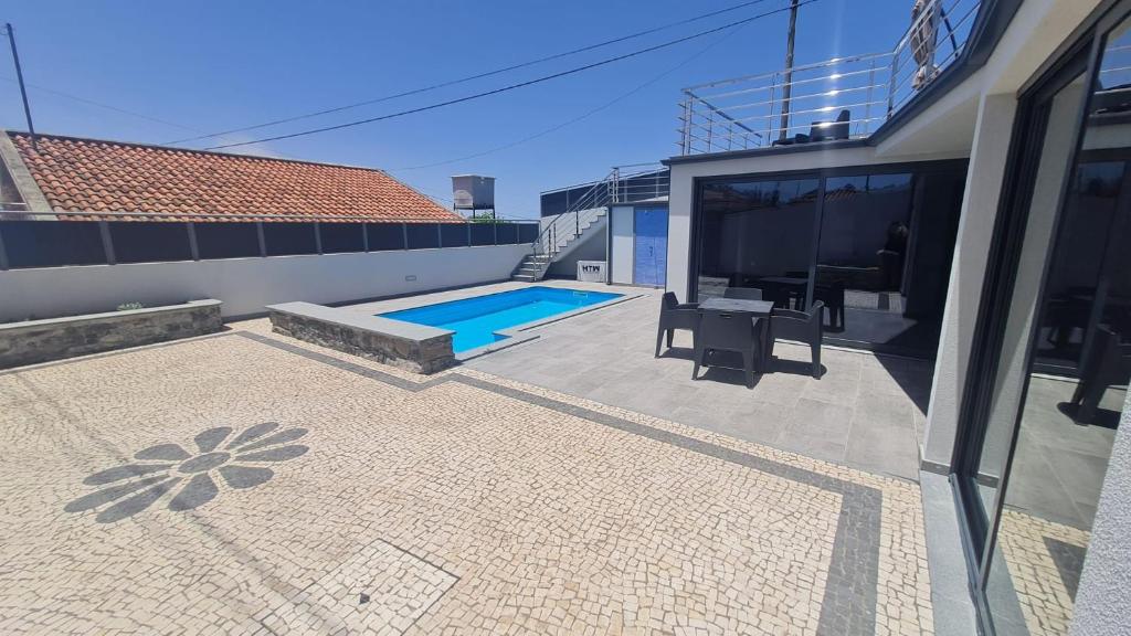 a house with a patio and a swimming pool at Casa Santi Stefany in Arco da Calheta