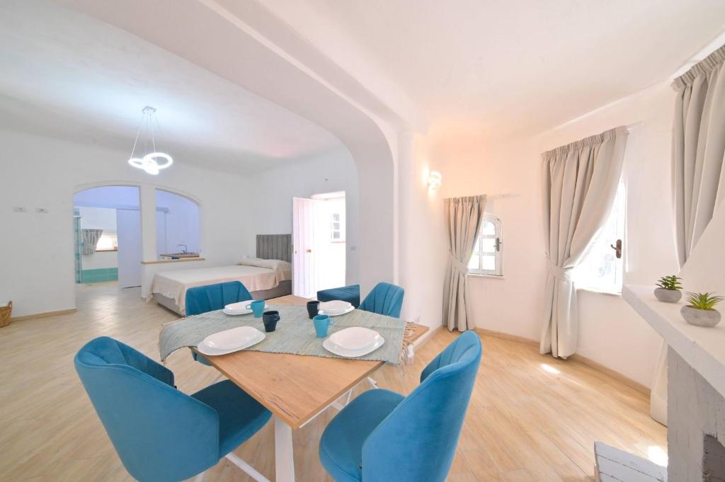 伊斯基亞的住宿－Villa Aida，一间带桌子和蓝色椅子的用餐室