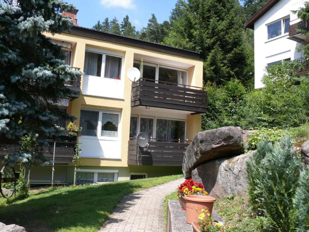 a building with a balcony and flowers in a garden at Ferienwohnung Dittmar am Kaffeehof in Bad Liebenzell