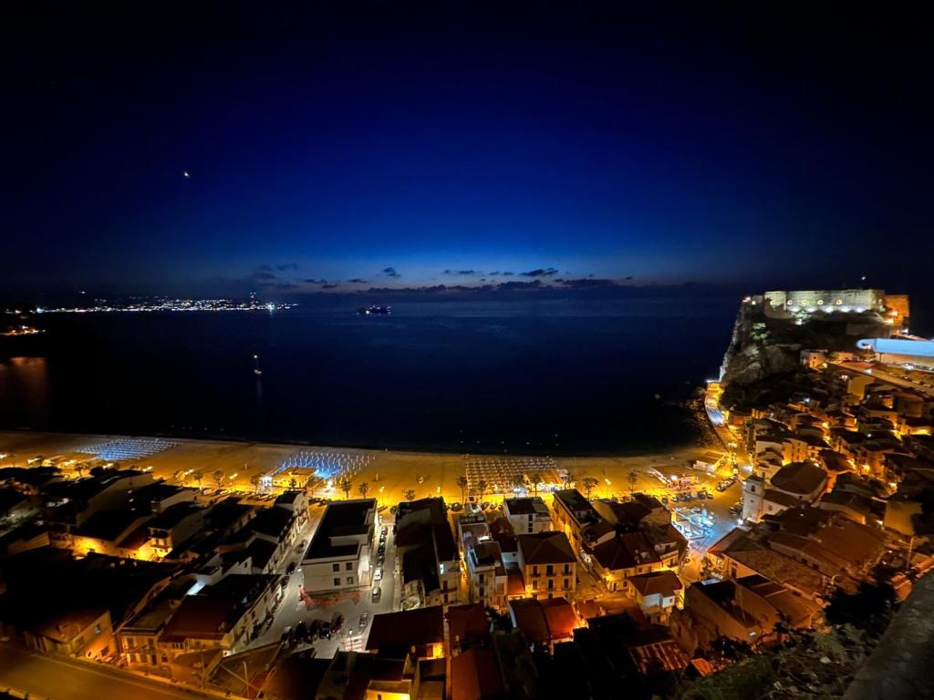 a city at night with the ocean in the background w obiekcie Casa Marina w mieście Scilla