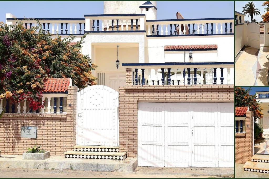 uma casa com uma porta de garagem branca e um edifício em Lot 46 em Souira Guedima