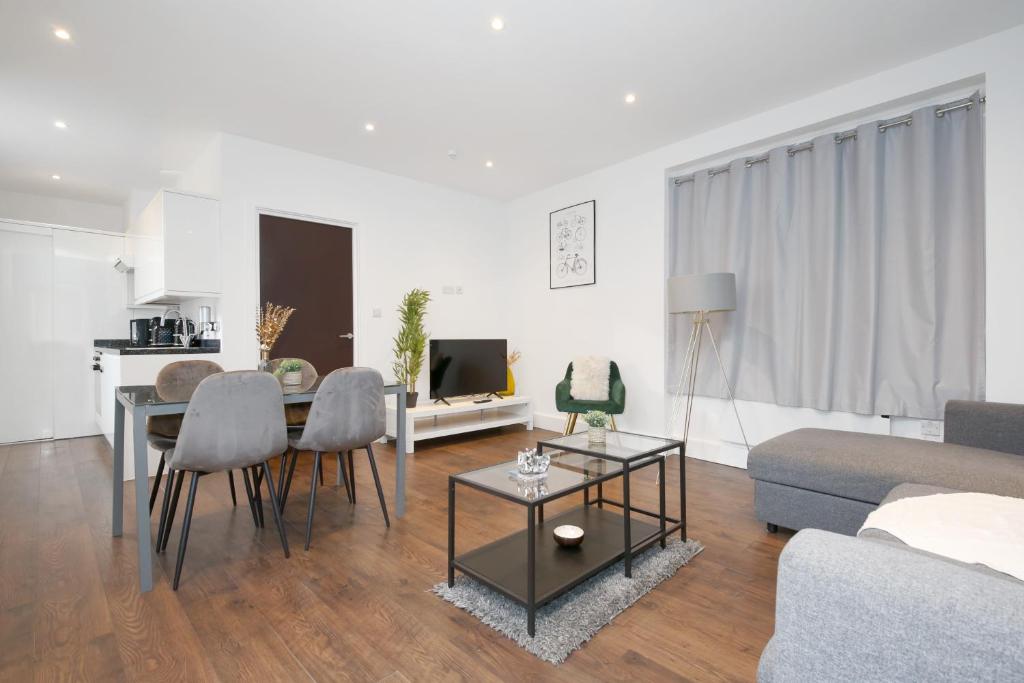 a living room with a table and chairs and a couch at Imperial Middlesex Street Apartments in London