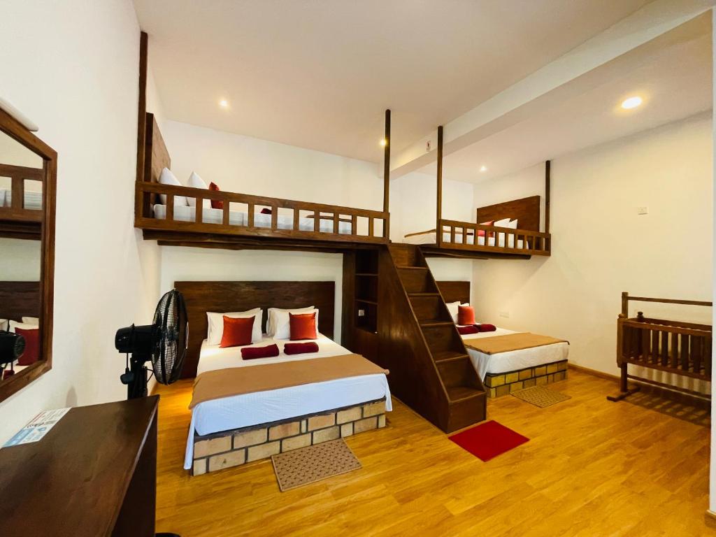 een slaapkamer met 2 stapelbedden en een trap bij Poomaz Peace Palace in Ella