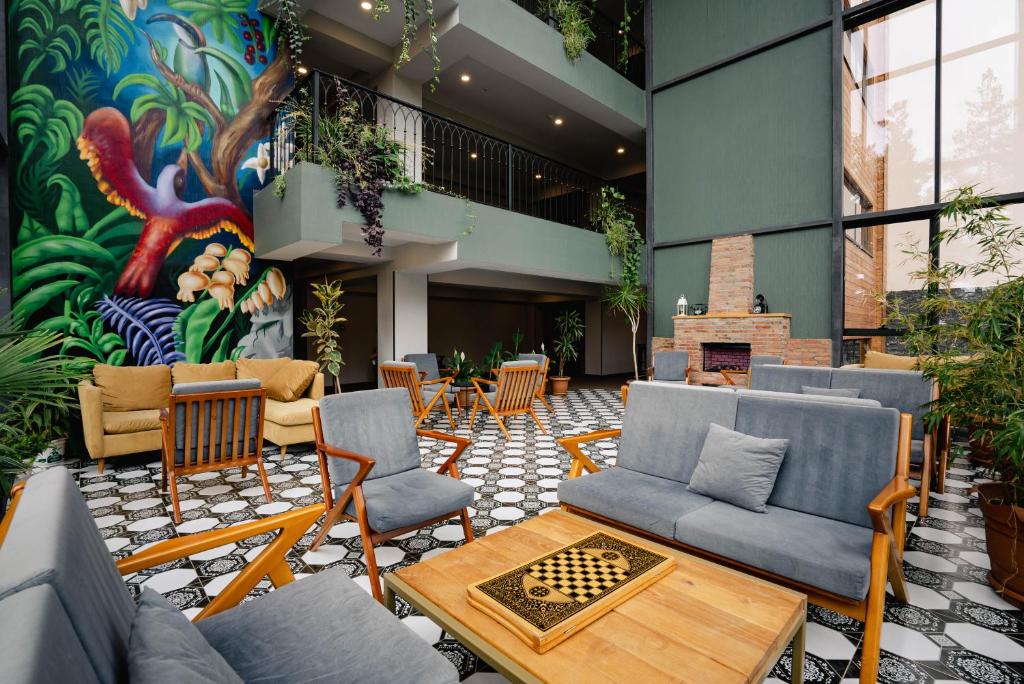 a lobby with couches and tables and a mural at Bakuriani Inn in Bakuriani