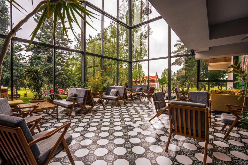 a conservatory with chairs and tables and windows at Bakuriani Inn in Bakuriani
