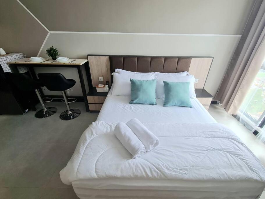 Cette chambre comprend un lit avec des draps blancs et des oreillers bleus. dans l'établissement 2R2B Apartment 10 mins to KLCC, à Kuala Lumpur