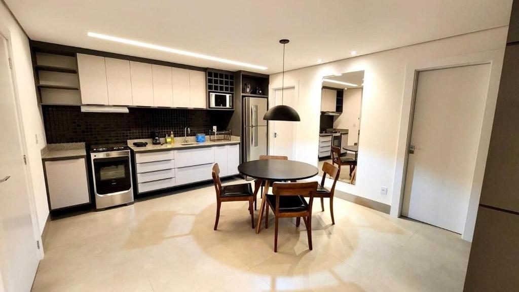 a kitchen with a table and chairs in it at Loft Confortável e Elegante com Quarto Fechado in Campo Grande