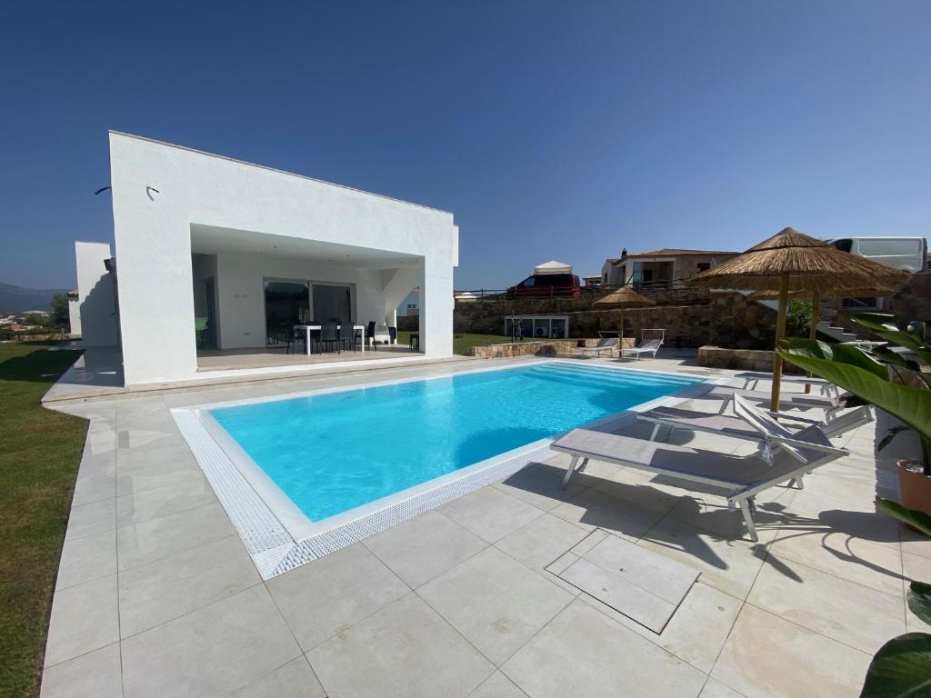 een villa met een zwembad en een patio bij Villa Lorisa in Tanaunella