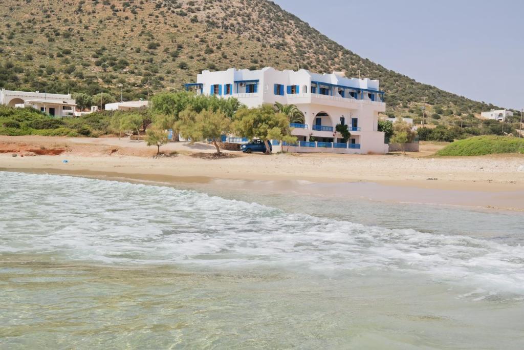 a white house on the beach next to the water at Paradise Studios in Agiassos