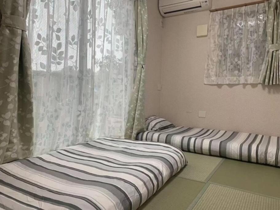 Postel nebo postele na pokoji v ubytování 江ノ島HOME