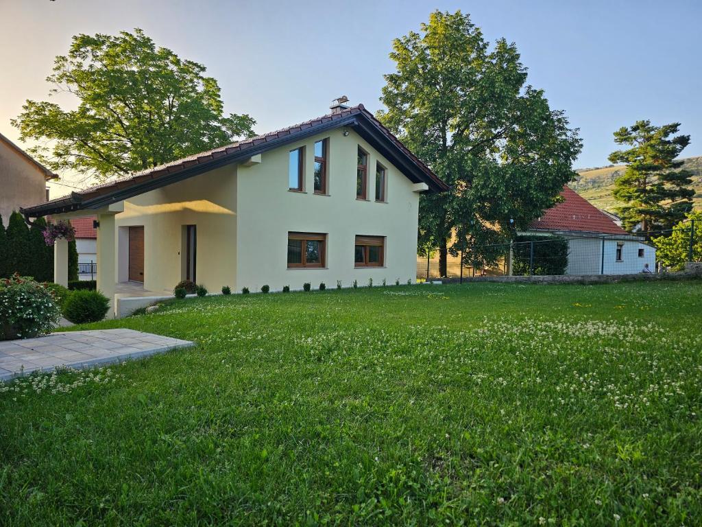 a house with a green lawn in front of it at Apartman Marin in Livno