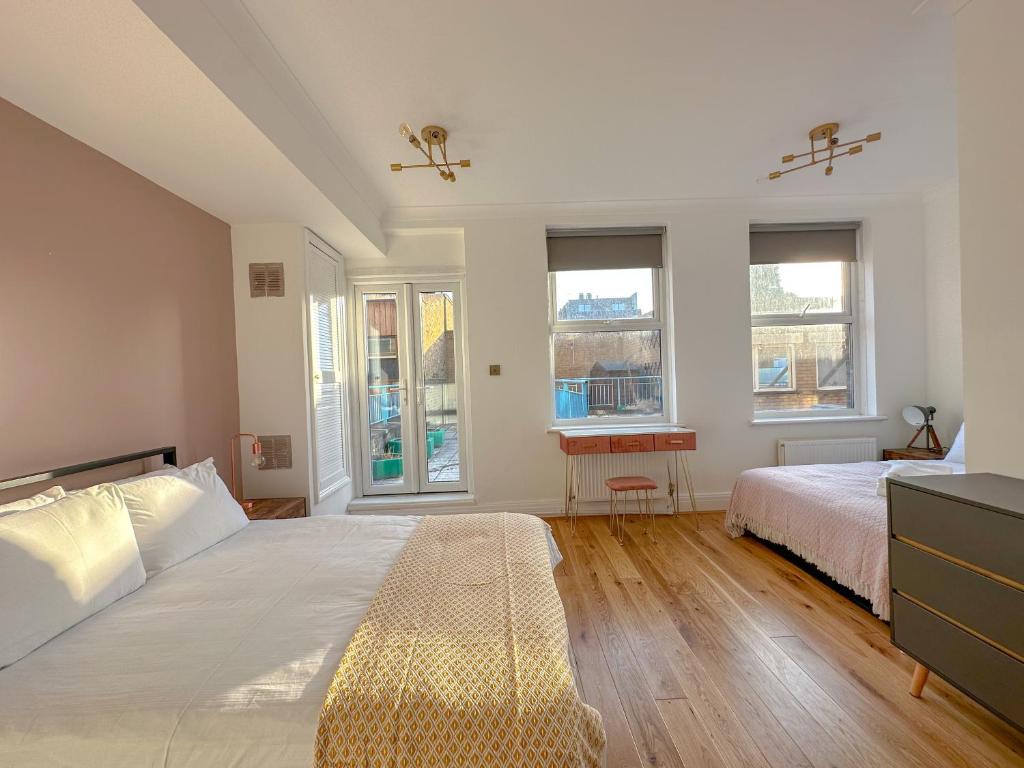 a bedroom with a large bed and two windows at Chancery Lane Residenses in London