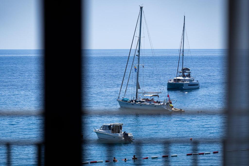 two boats floating in the water in the ocean at Hotel California by Aycon in Sveti Stefan