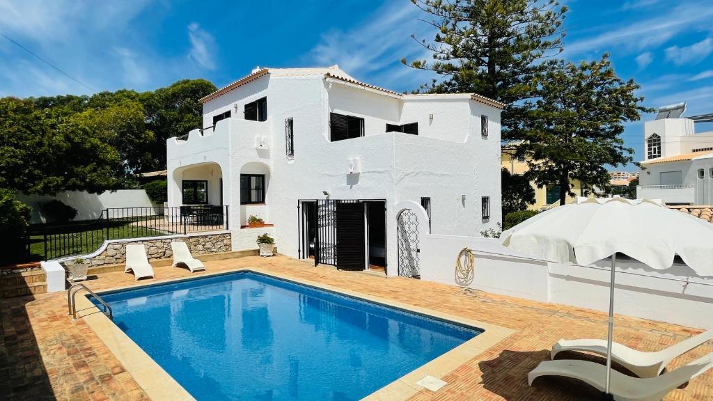une maison blanche avec une piscine en face de celle-ci dans l'établissement El Gharbe by Check-in Portugal, à Albufeira