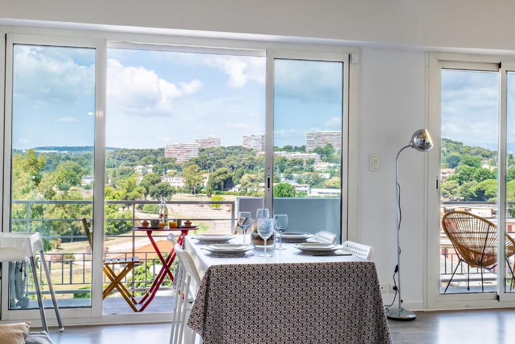 - une salle à manger avec une table et une vue sur la ville dans l'établissement Bright cocoon with sea views, à Cagnes-sur-Mer