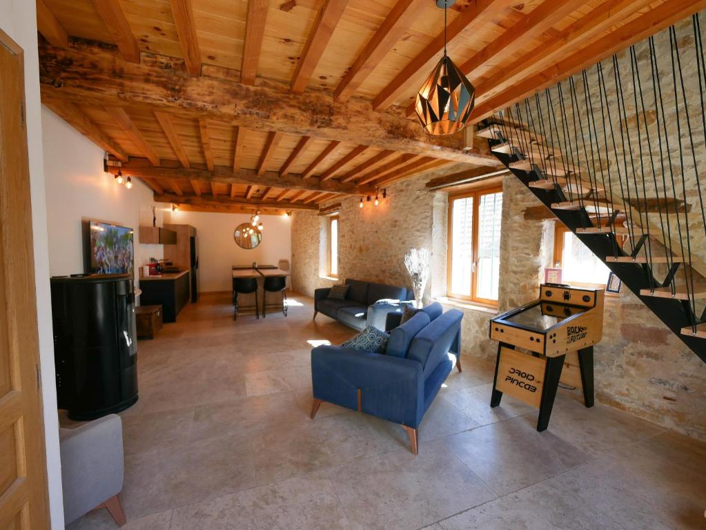 sala de estar con sofá azul y escalera en Gite de la Source-maison climatisée, 