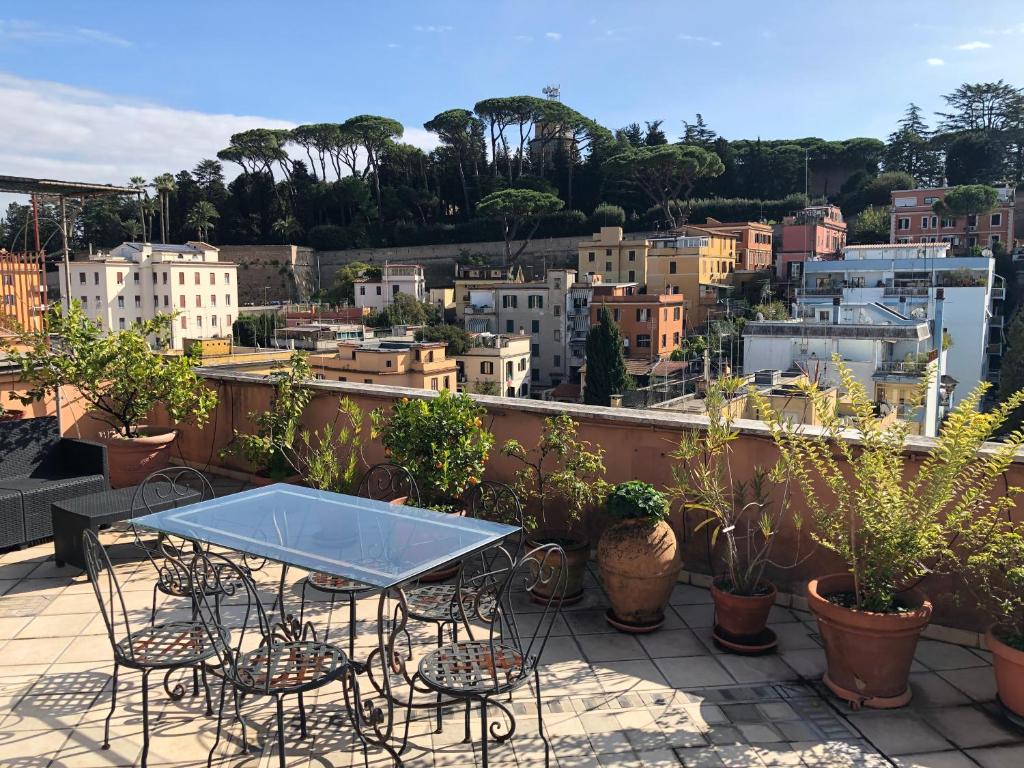 einen Tisch und Stühle auf einem Balkon mit Pflanzen in der Unterkunft Angelo Emo Terrace in Rom