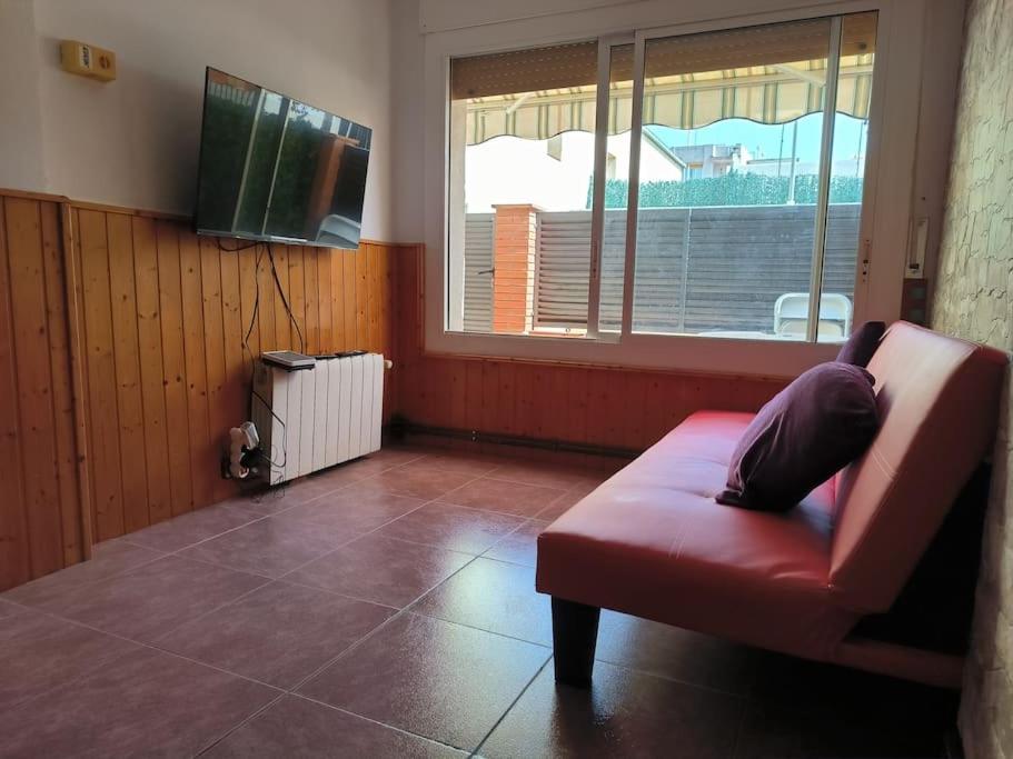 ein Wohnzimmer mit einem roten Sofa und einem Fenster in der Unterkunft Nice house at the beach near Barcelona, new in Premiá de Mar
