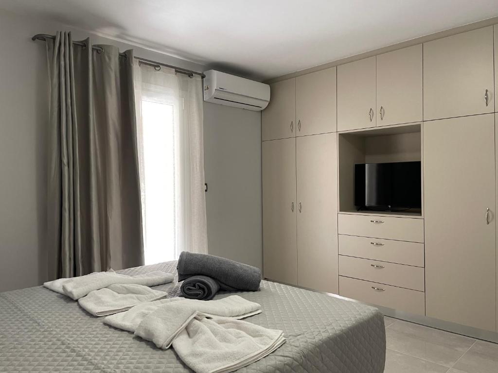 a bedroom with a bed with towels and a television at Arian Apartments in Argostoli