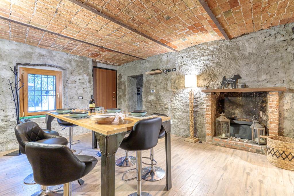 a dining room with a table and a fireplace at Cascina Liebe con Idromassaggio in Ozzano Monferrato
