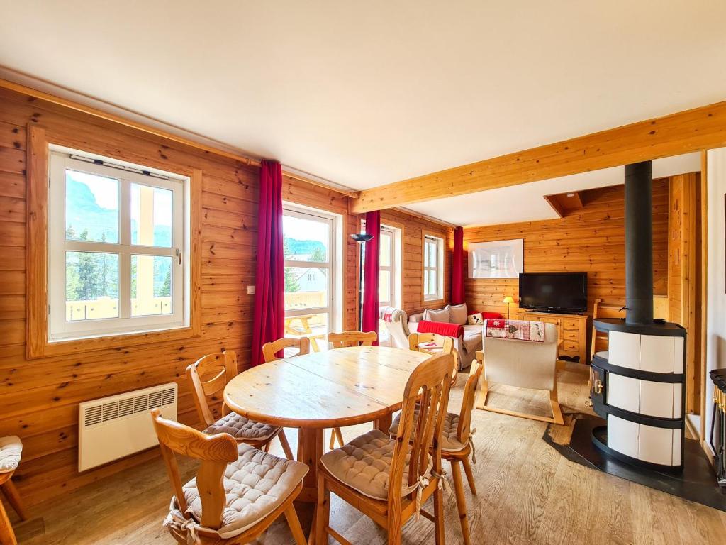 a dining room with a table and chairs and a fireplace at Chalet Flaine, 4 pièces, 8 personnes - FR-1-425-198 in Arâches-la-Frasse