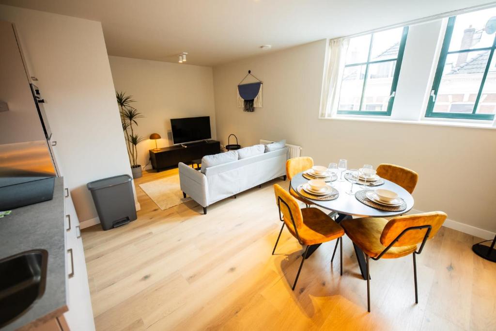 een woonkamer met een tafel en stoelen en een bank bij Astonishing 3 Bedroom Serviced Apartment 73m2 in Rotterdam